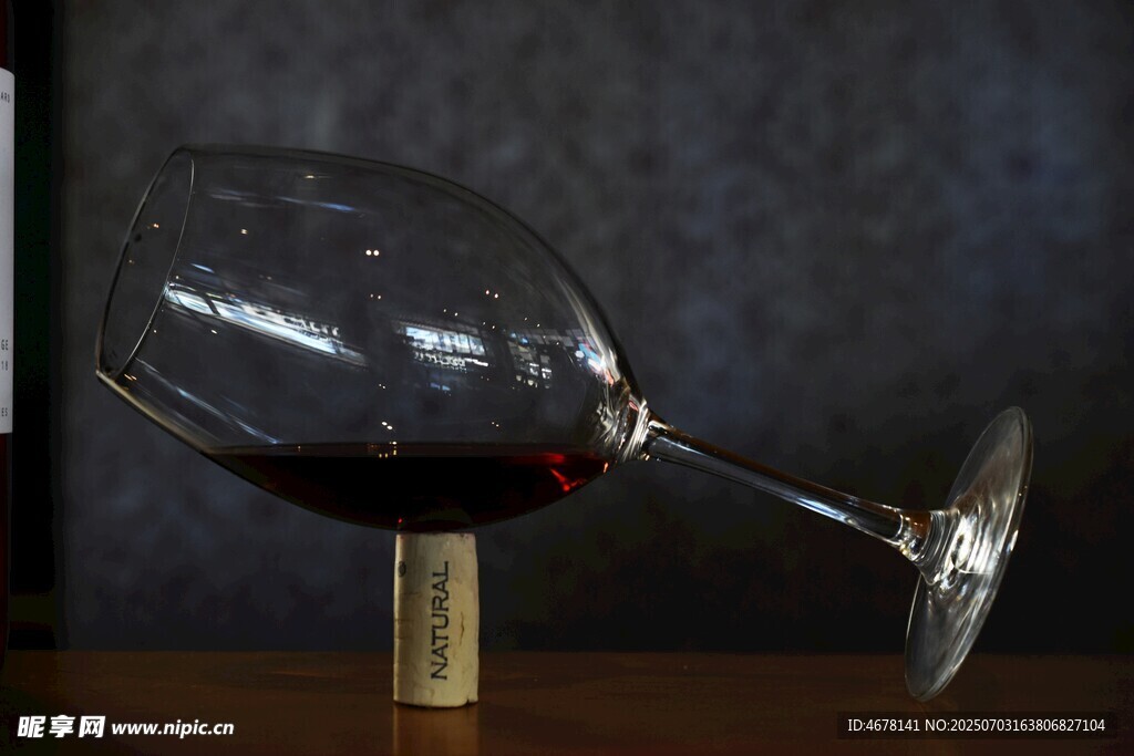 倾斜红酒杯中的深红色佳酿