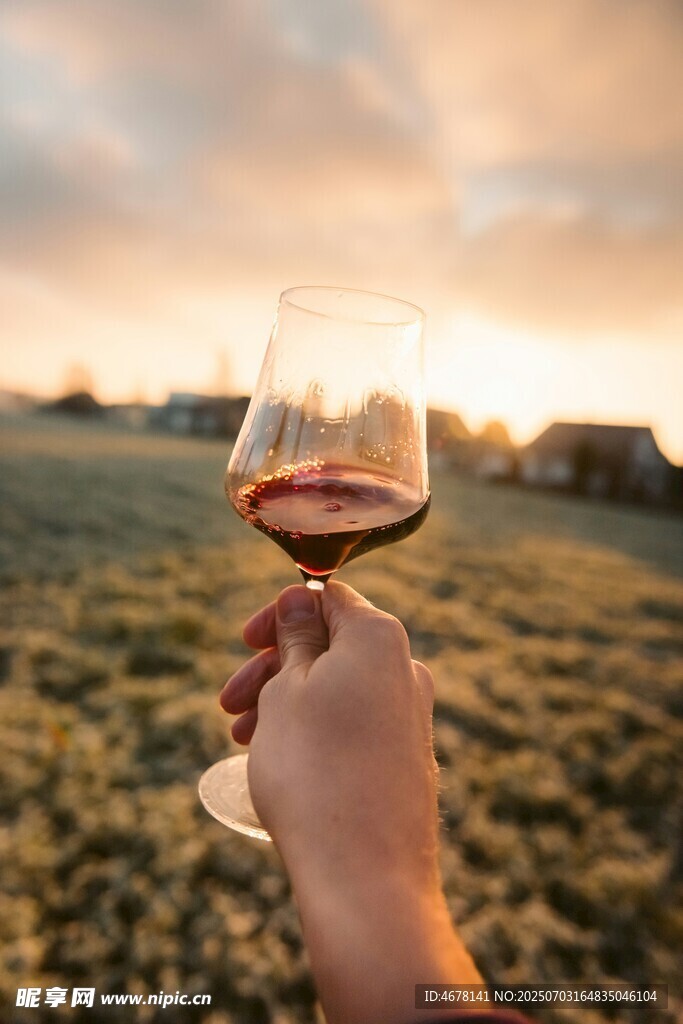 夕阳下手持红酒杯的惬意