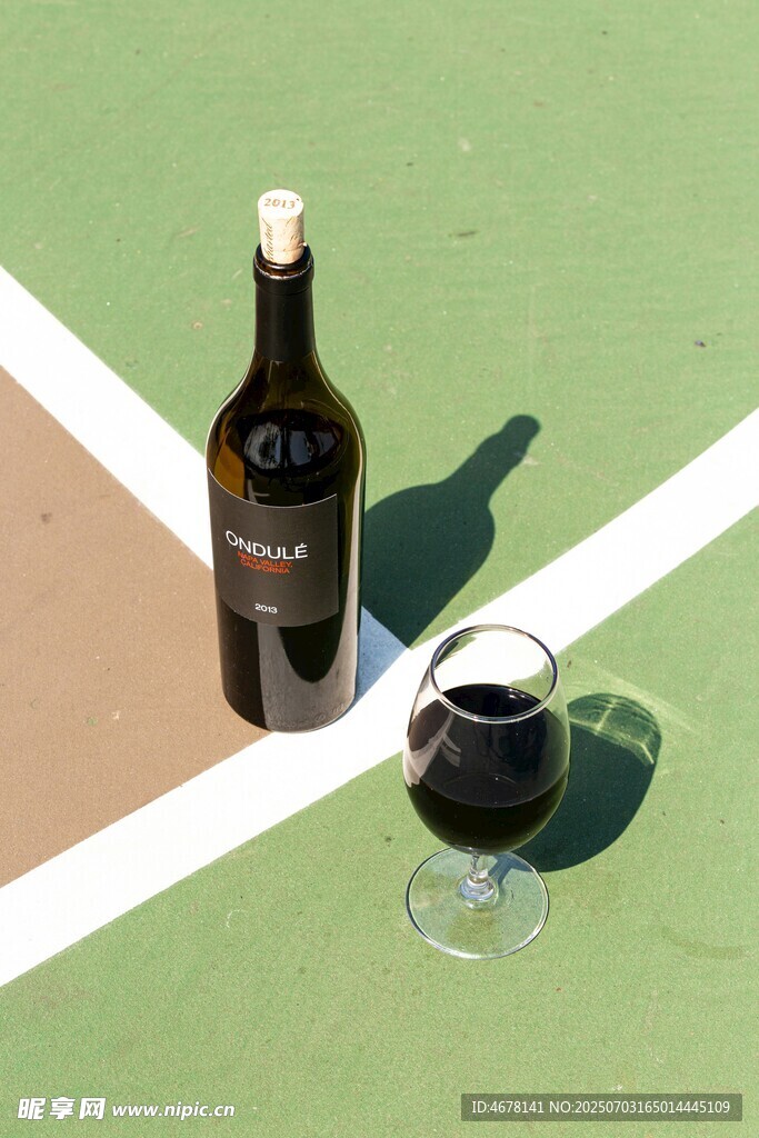 户外绿地上的红酒与酒杯