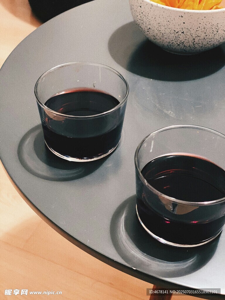 两杯红酒置于圆形托盘上