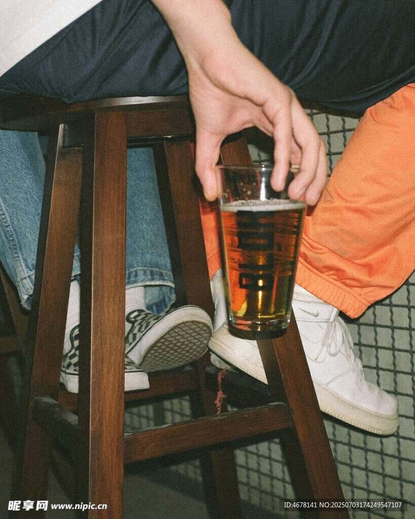 手捧杯坐于木凳旁