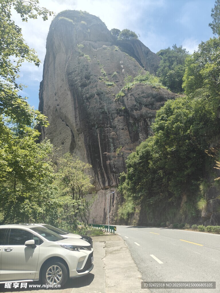 公路旁的巍峨山石与汽车