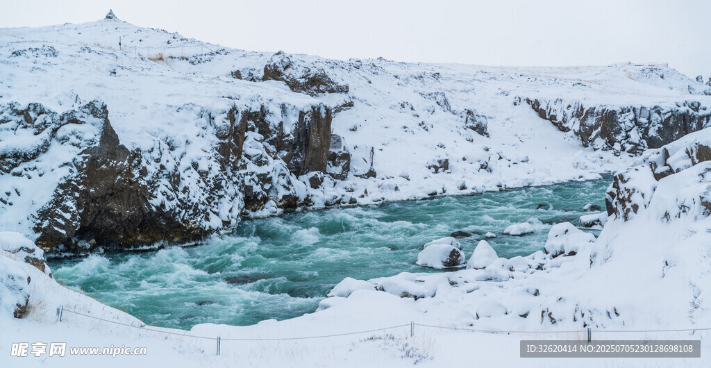 冰雪覆盖下的碧绿湍急河流