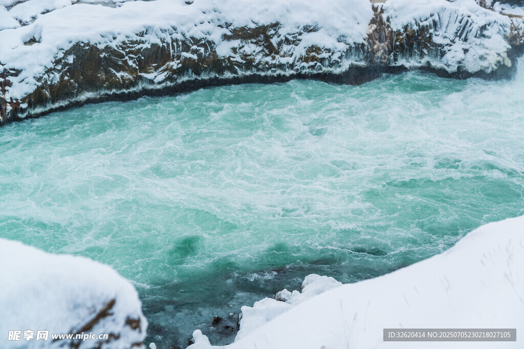 冬日冰雪环绕的碧绿湖水