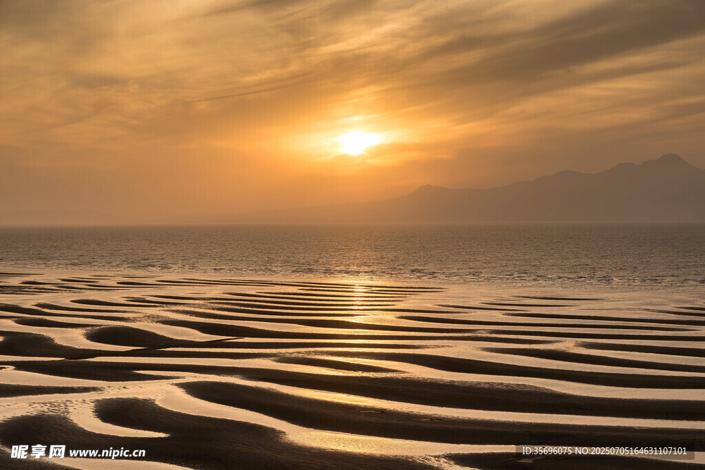 夕阳下的沙滩与波光海面