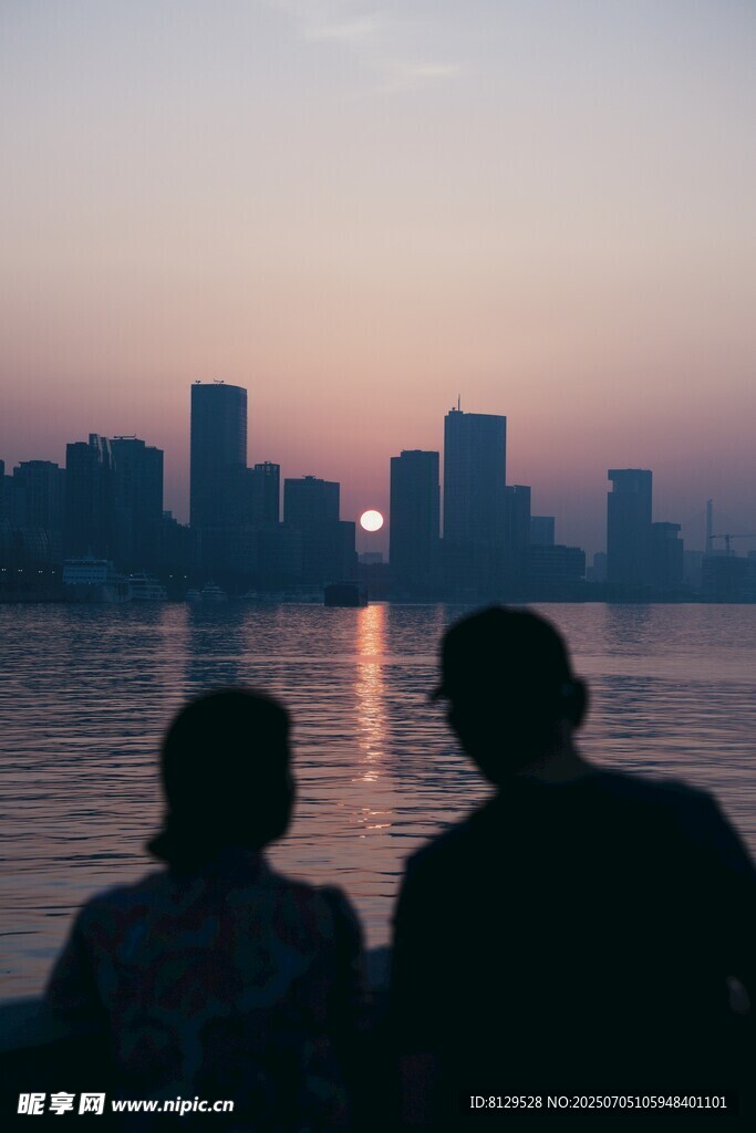 夕阳下情侣赏城市湖景