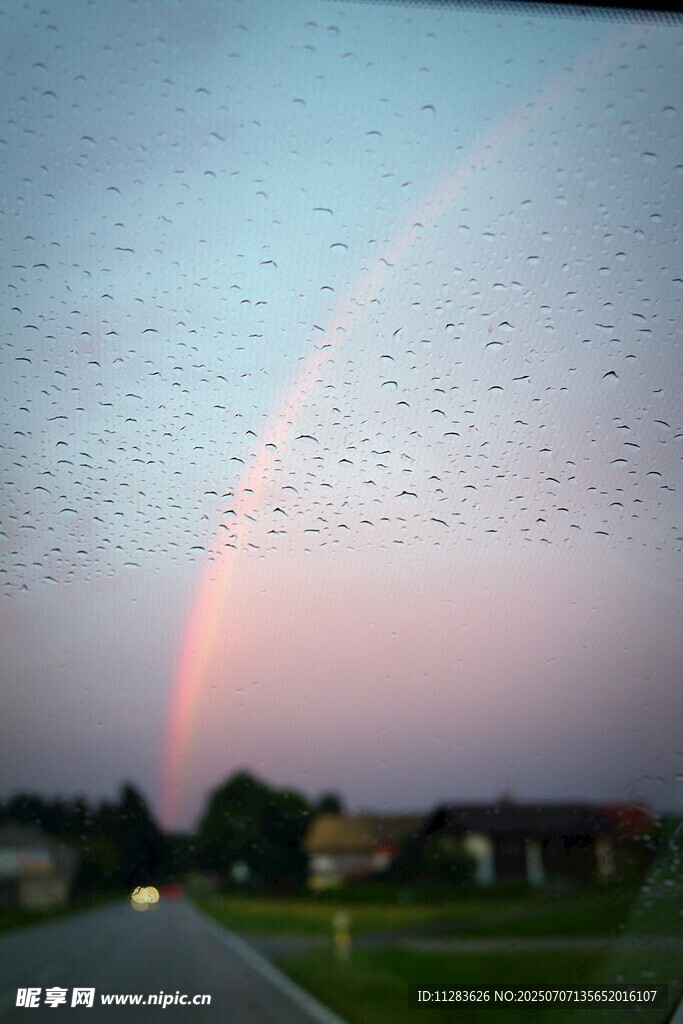 车窗上雨滴后的绚丽彩虹