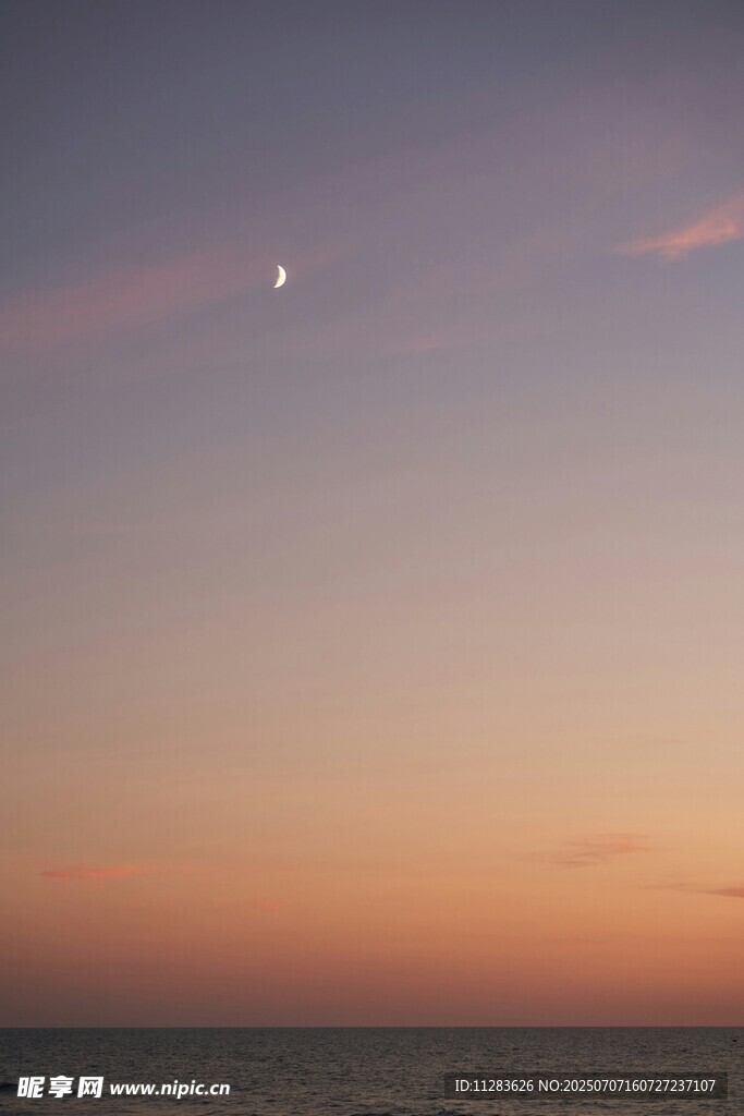 海边日落时的天空与月亮