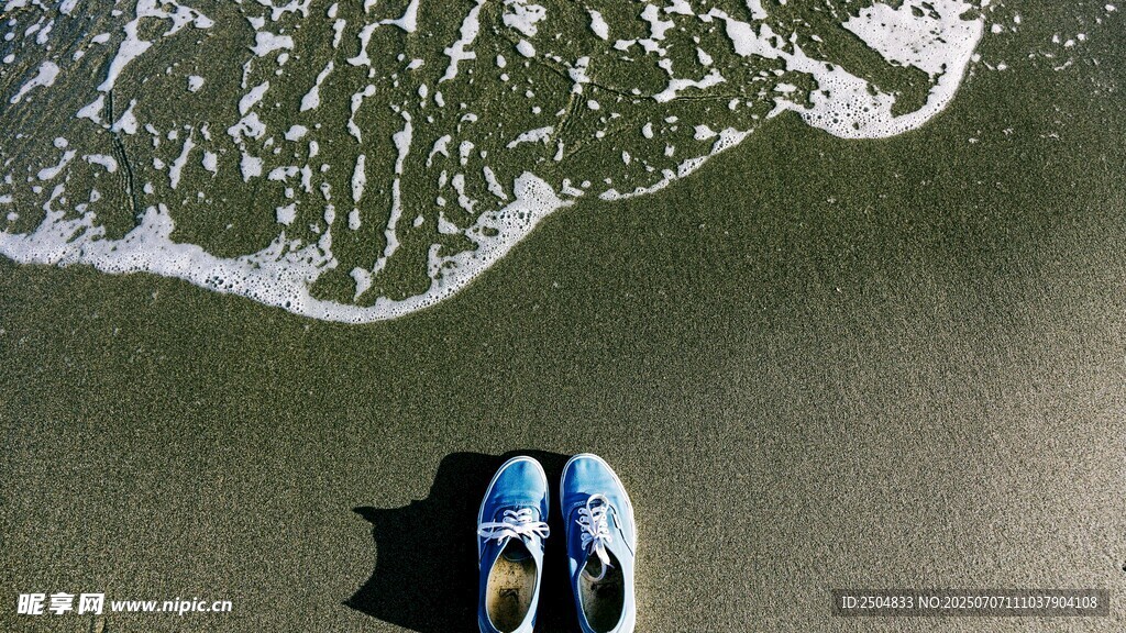 沙滩上的蓝鞋与海浪