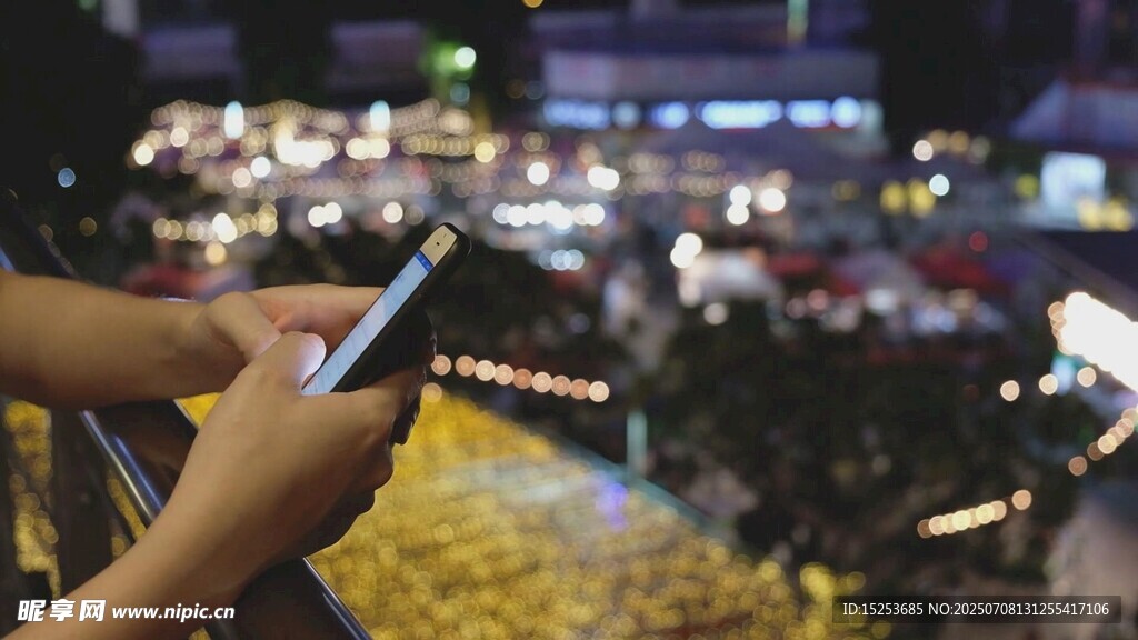 夜晚手持手机俯瞰城市景