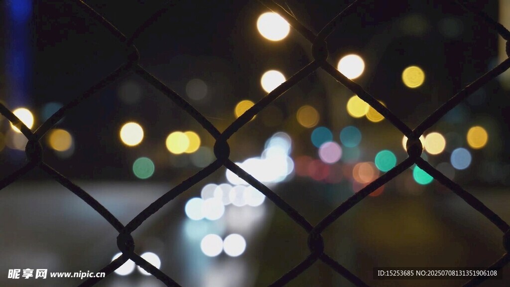 透过铁网看城市夜景