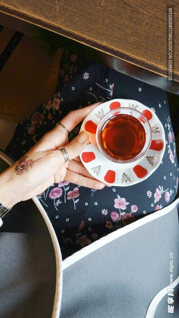 手捧花纹杯中的红茶