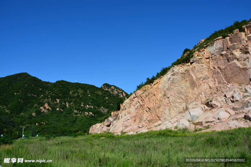 山间裸露岩壁与葱郁草地