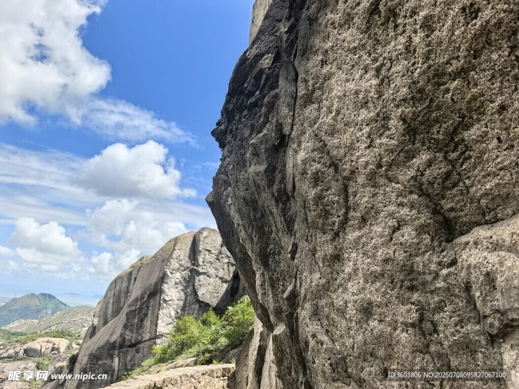 陡峭岩壁与蓝天白云景观