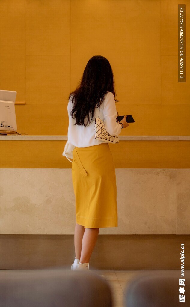 女子于室内专注使用手机
