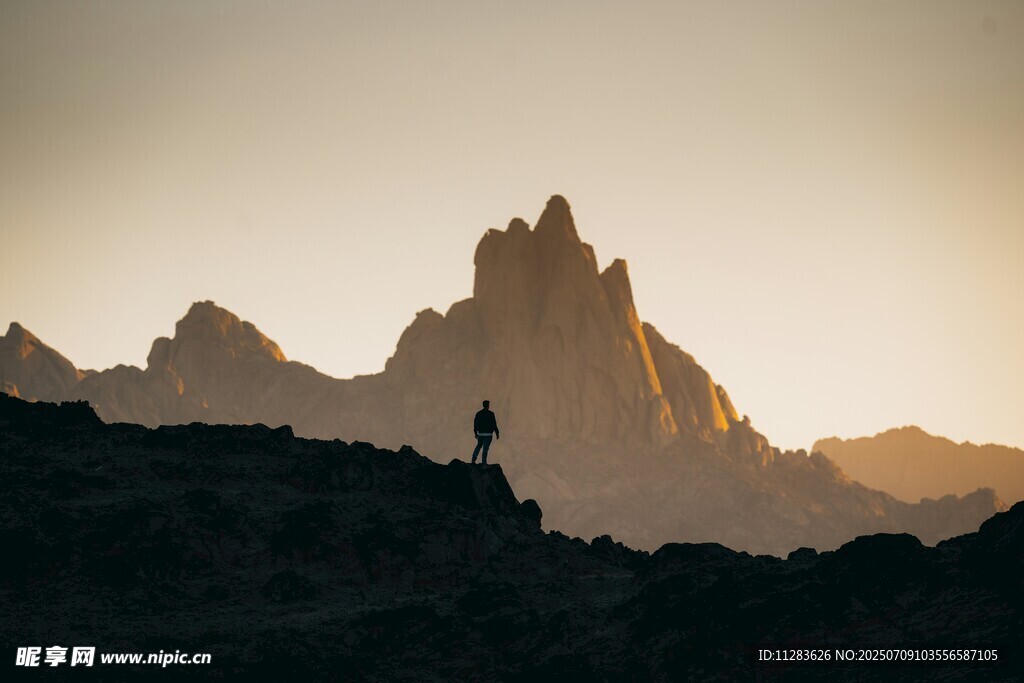 夕阳下的孤行者与壮丽山峰