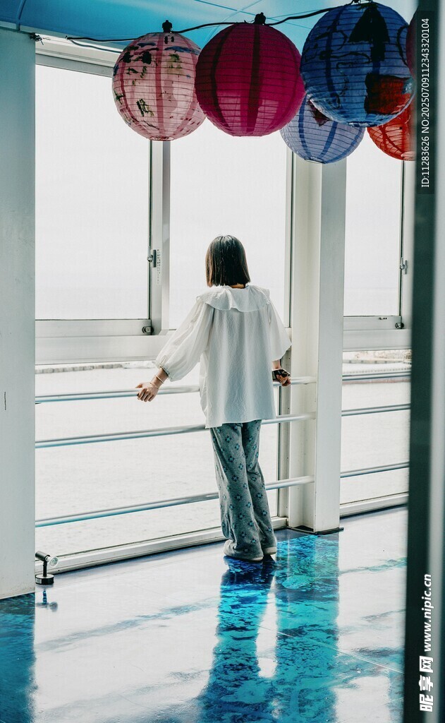 女子赏多彩灯笼于通透空间