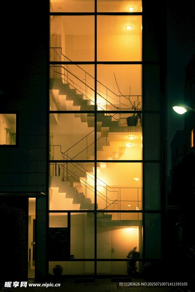 夜晚玻璃建筑内的明亮楼梯