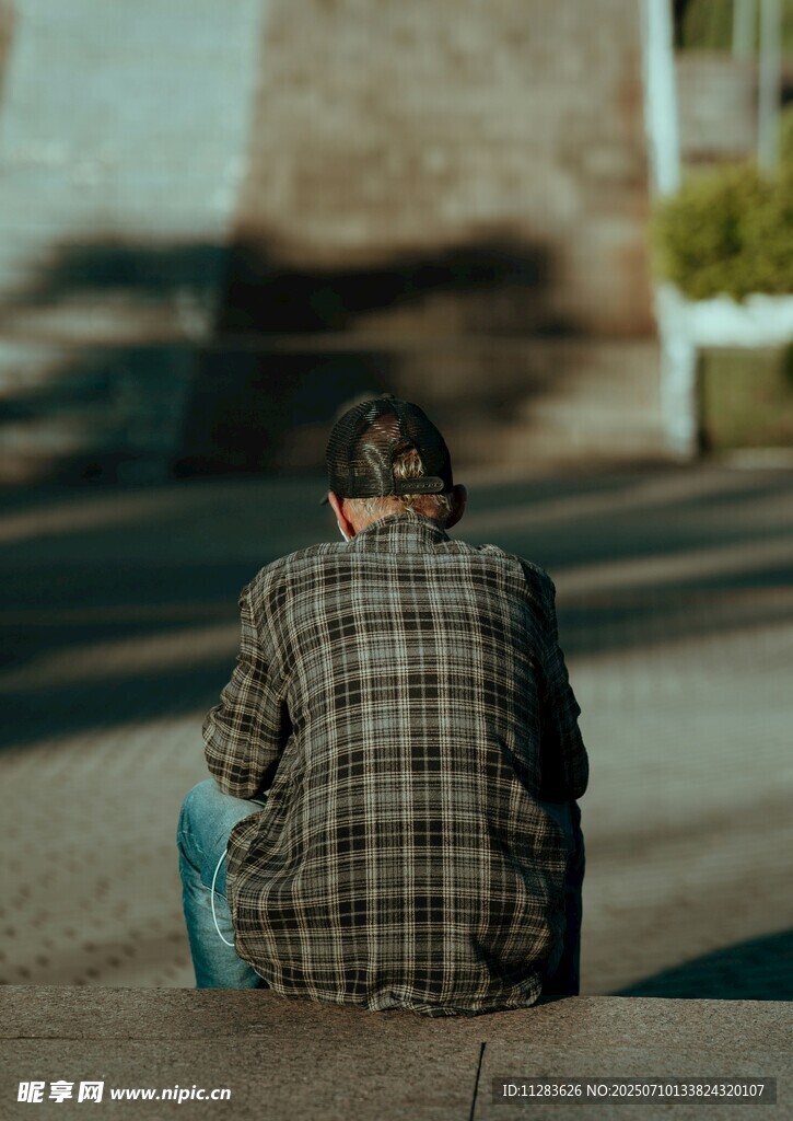 独坐街头的格子衣男子