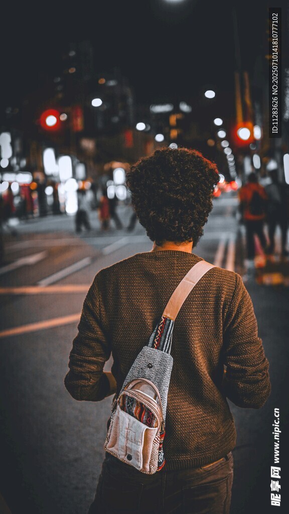 夜晚街头独行的背包身影