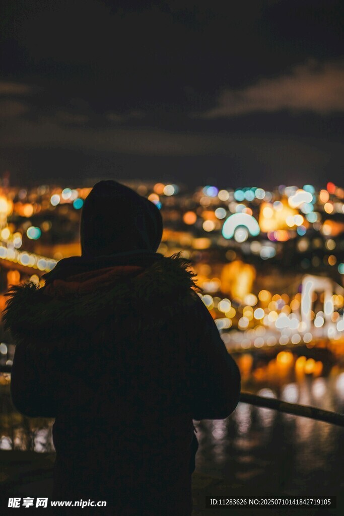 夜晚城市前的孤独身影