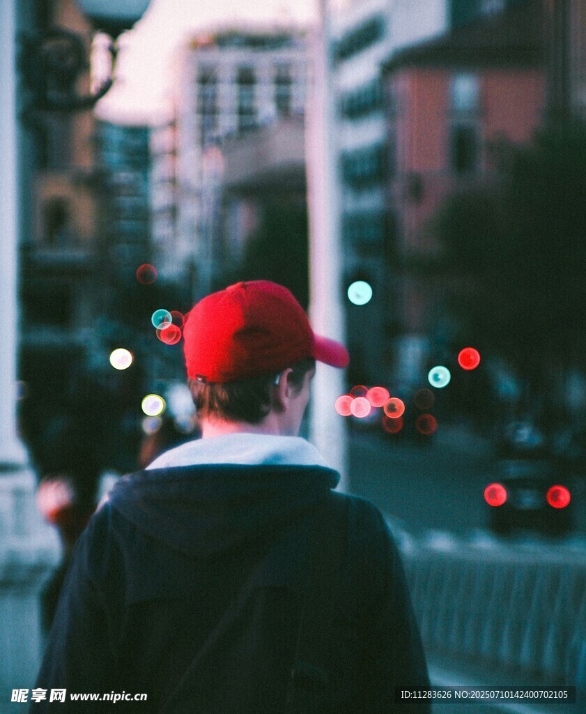 街头戴红帽男子背影