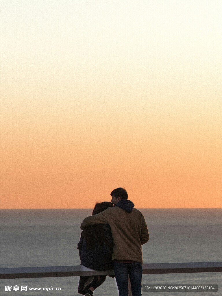 夕阳下情侣海边甜蜜依偎