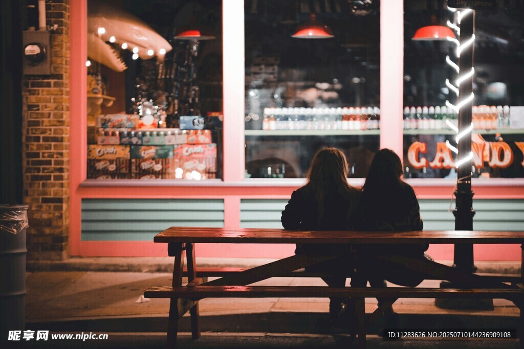 夜晚街边长椅上的两人身影