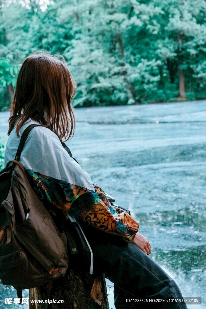 女孩背背包静赏湖景