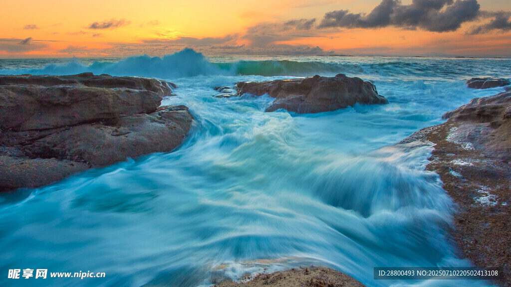 夕阳下海浪拍打礁石美景
