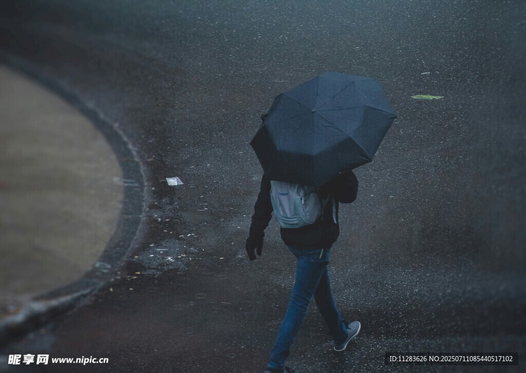 雨中撑伞独自行走的人