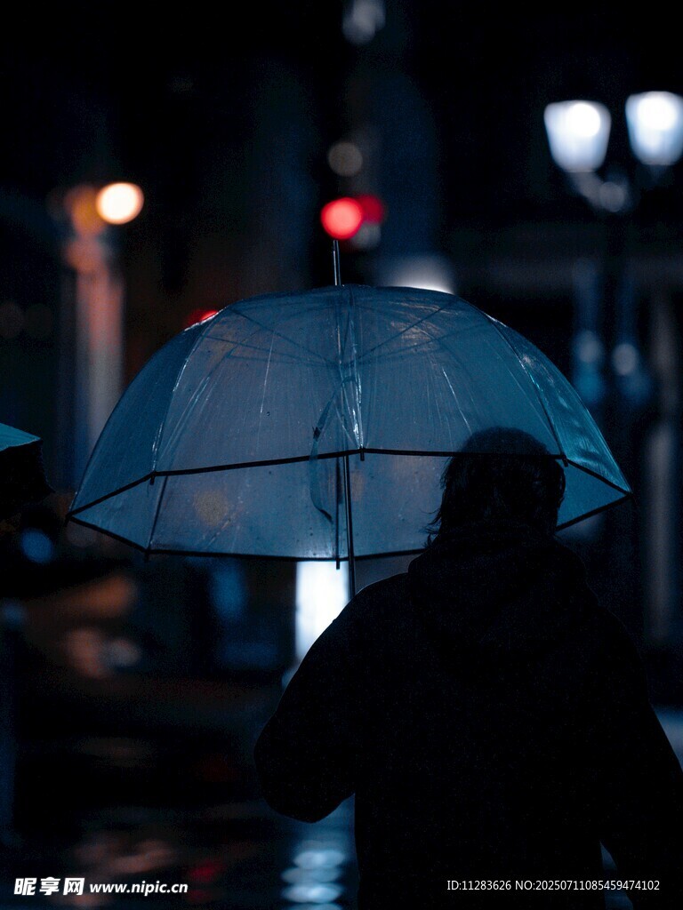 雨夜撑伞人的模糊身影