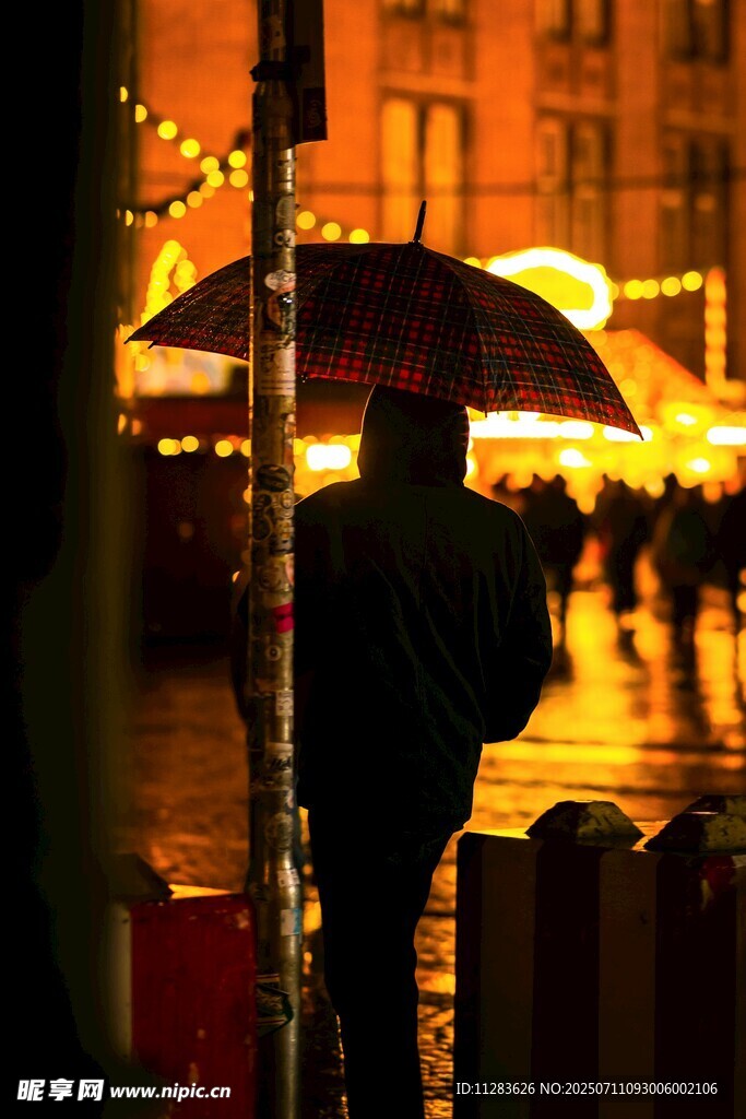 雨夜撑伞人的孤独身影