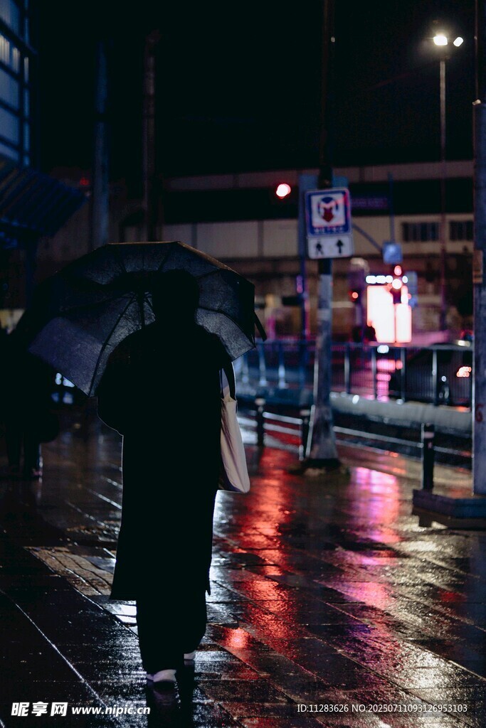 雨夜街头撑伞独行的身影