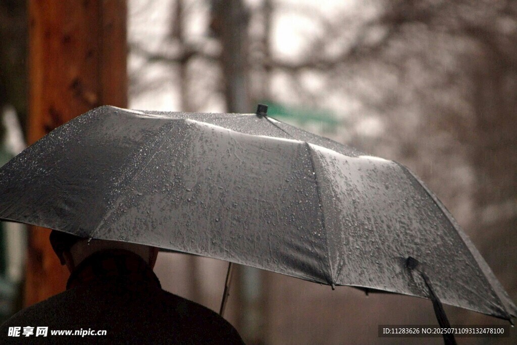 雨中撑伞人