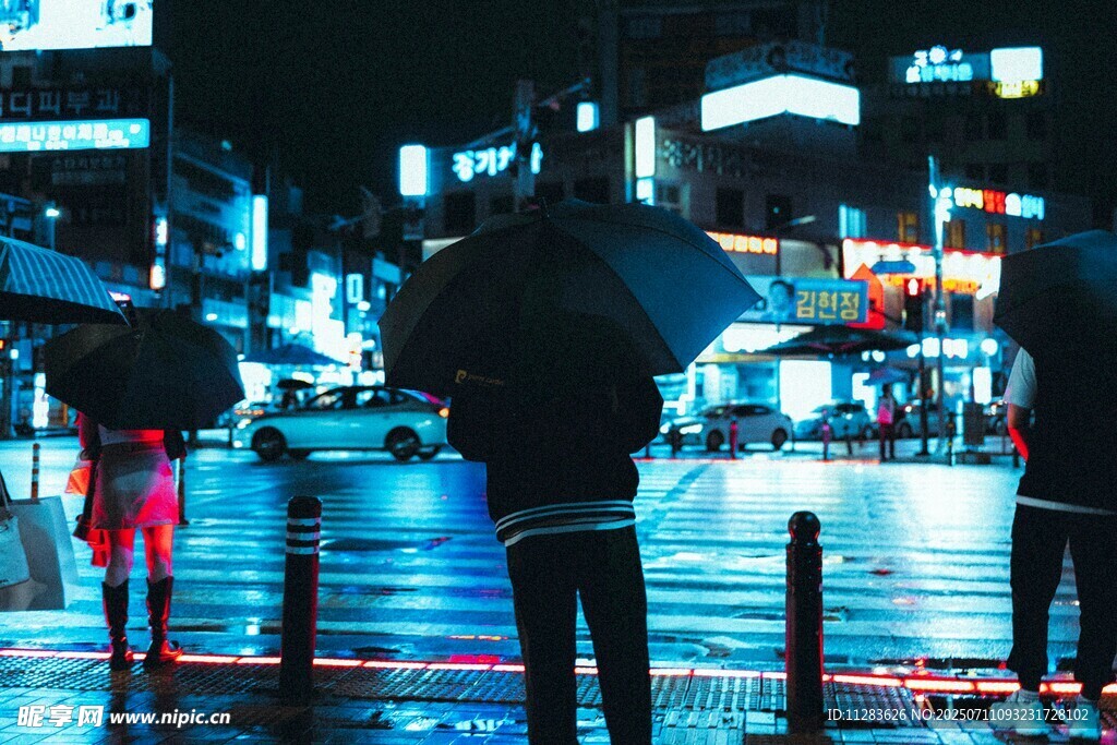 雨夜街头撑伞的行人身影