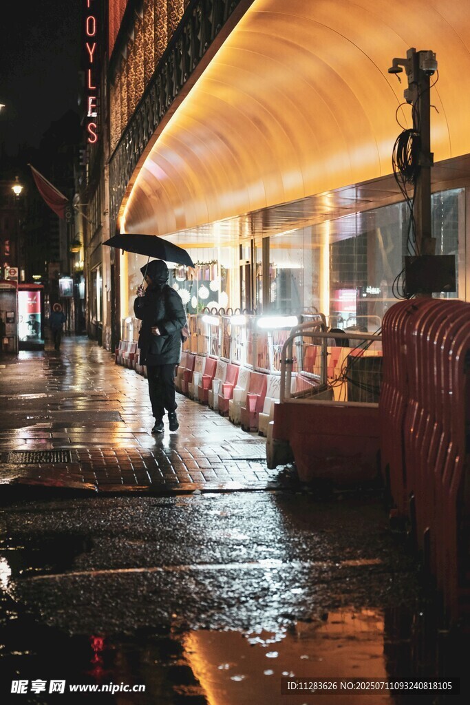 雨夜街头撑伞独行的身影