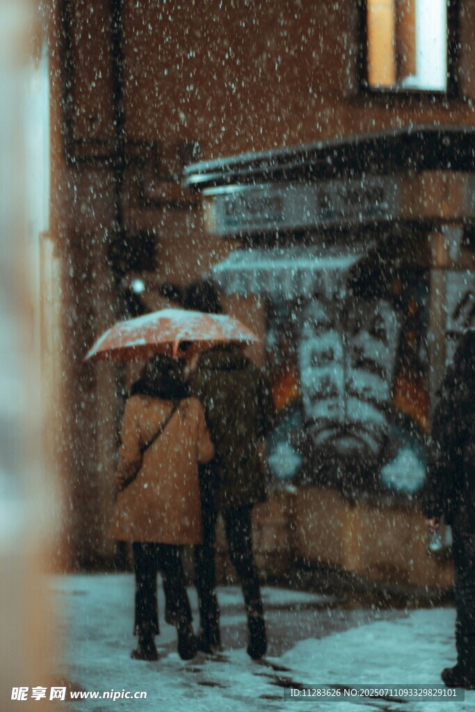 雪中街头撑伞的人群