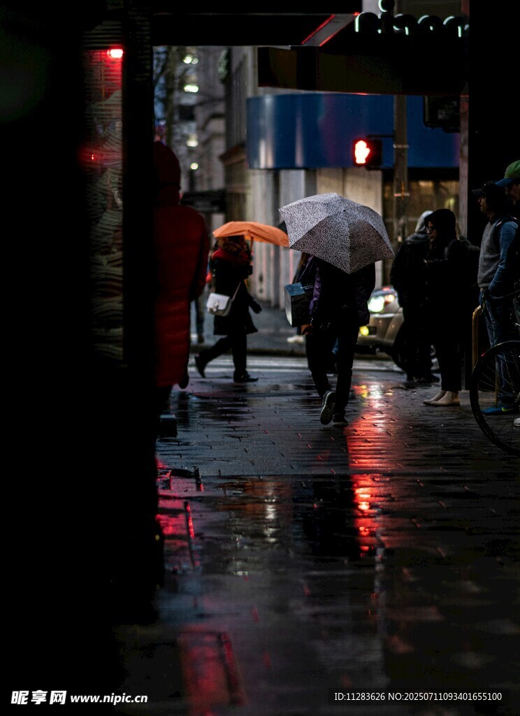 雨夜街头行人撑伞景象