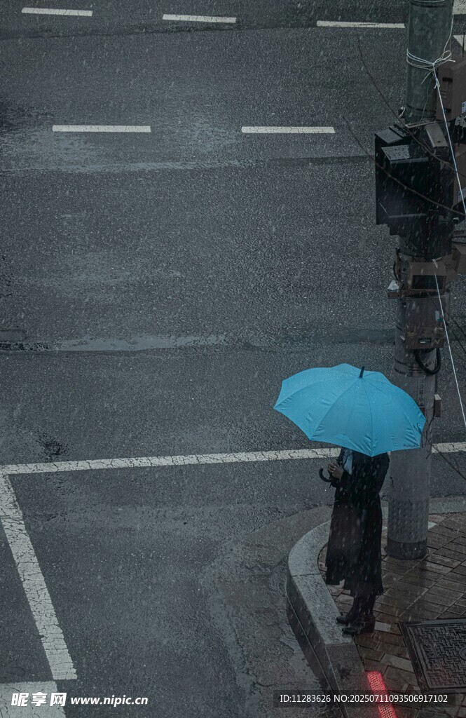 雨中撑蓝伞的行人