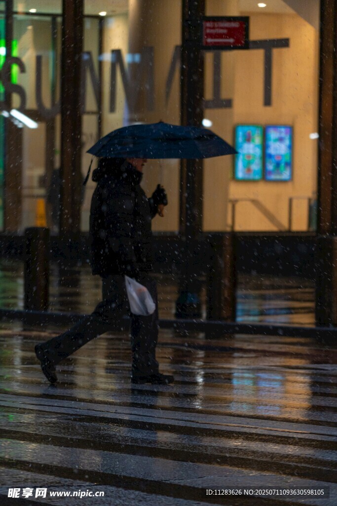 雨夜街头撑伞行走的身影