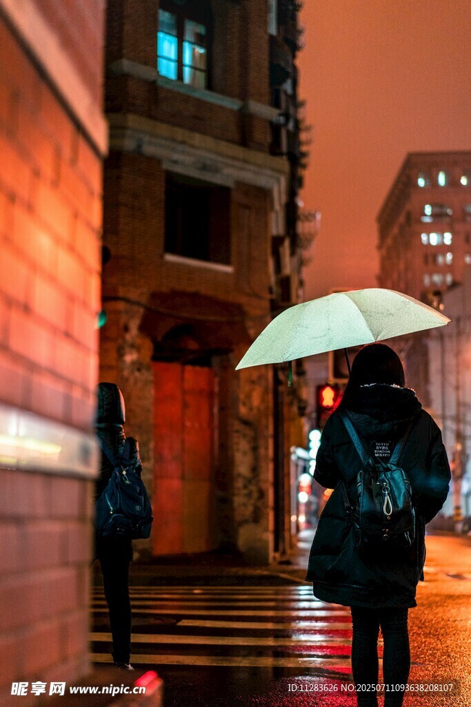 雨夜撑伞独行的街头身影