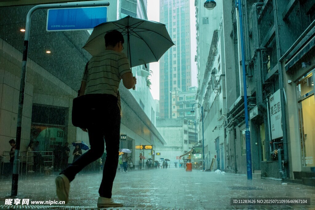 雨中街头撑伞行走的女子
