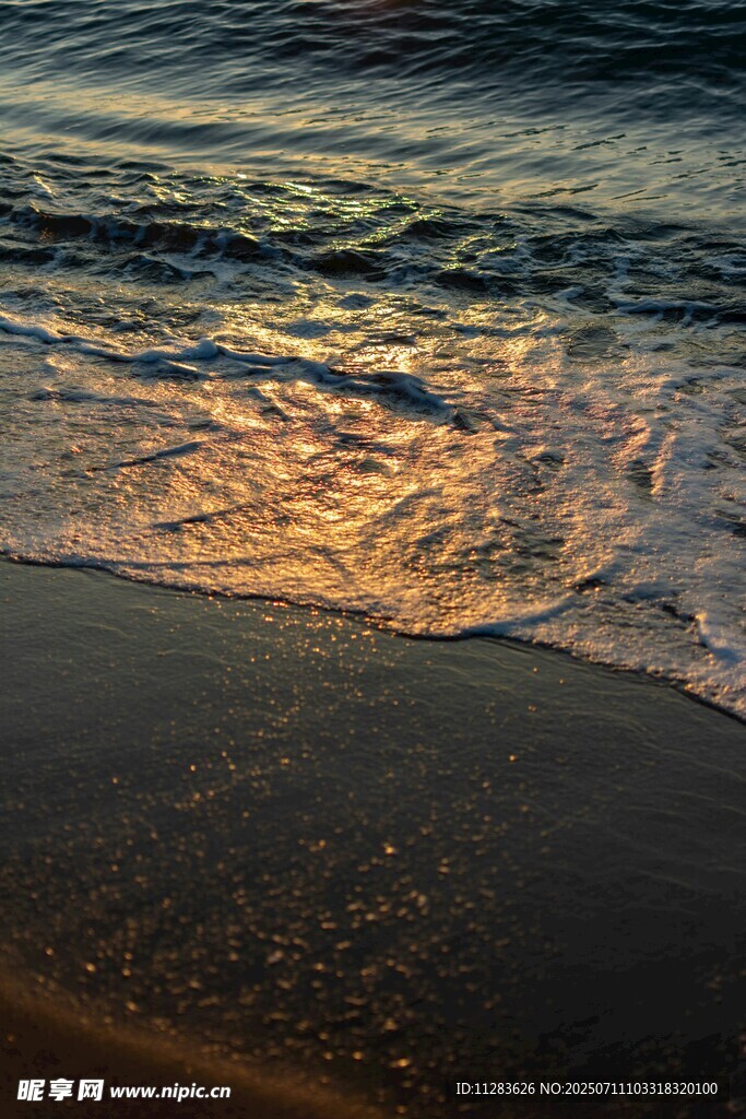 夕阳下的海浪轻拍沙滩