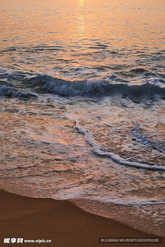 夕阳下的海浪轻拍沙滩