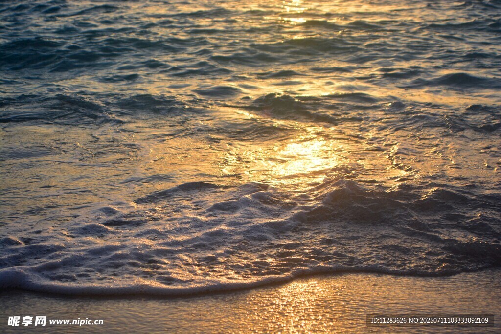 夕阳下的海浪轻拍沙滩