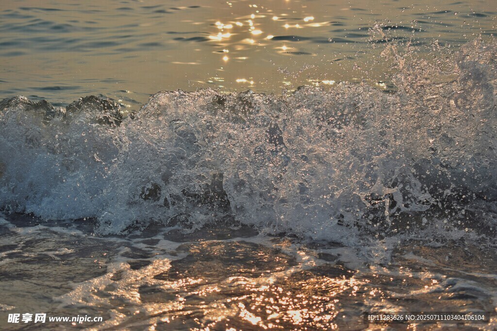 夕阳下的海浪拍打沙滩