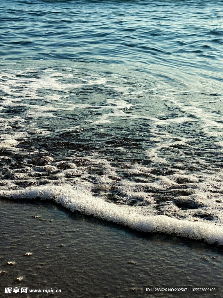 海边浪花拍打黑色沙滩