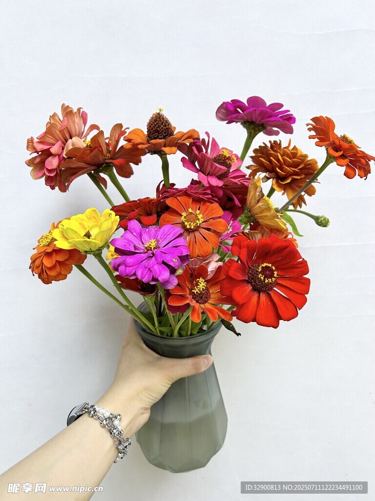 手捧多彩鲜花插于花瓶