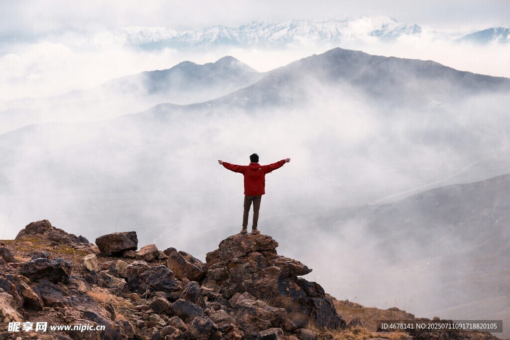 山顶红衣人张开双臂赏景